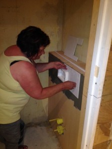 Jeannette plakt eerste tegel damestoilet